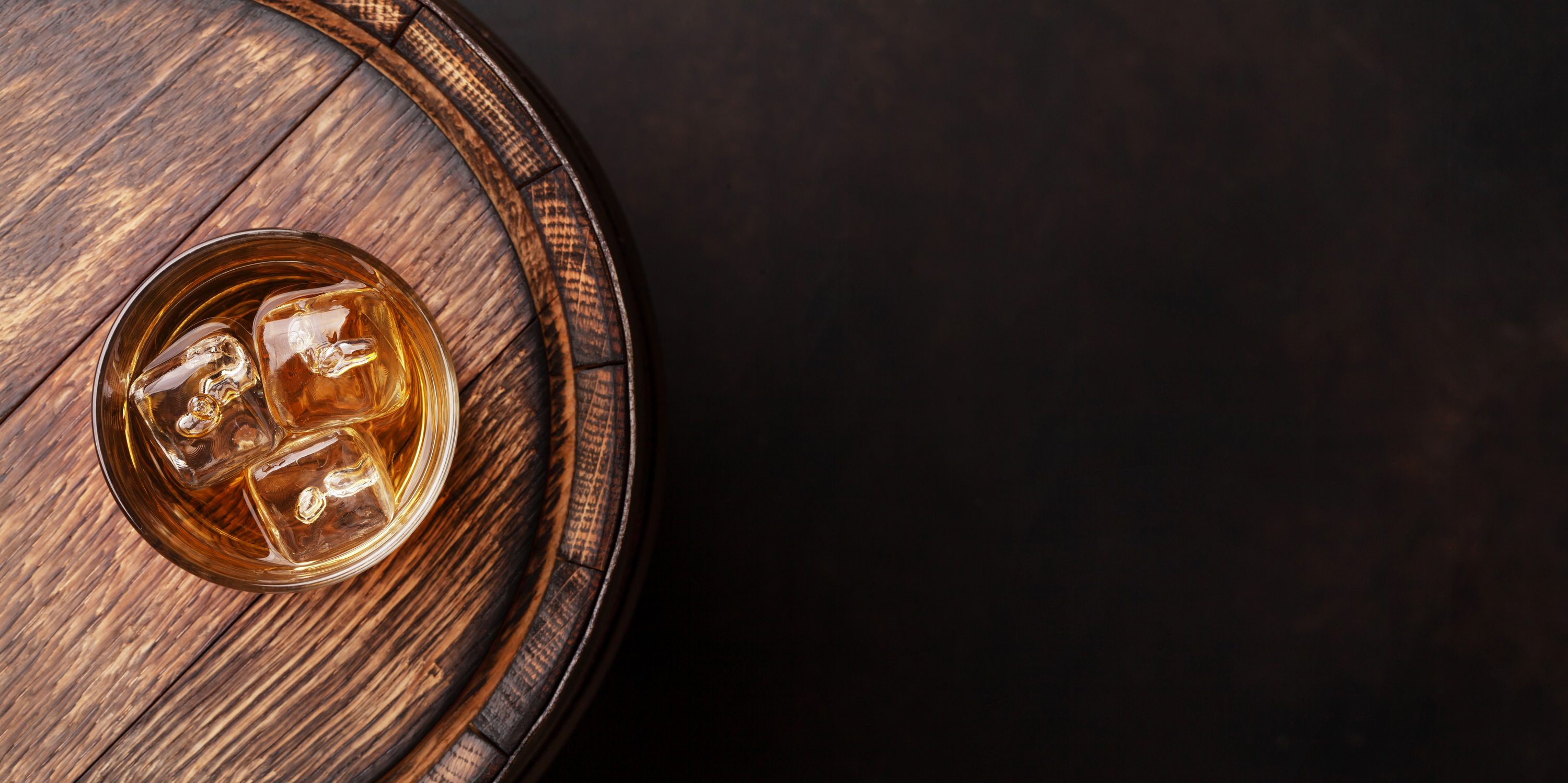 Scotch whiskey glass and old barrel